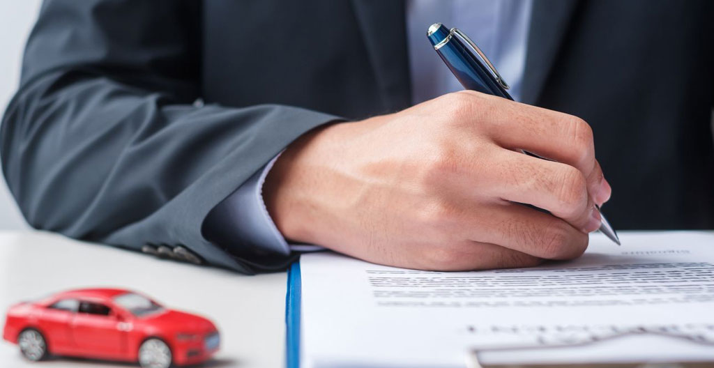 Un acheteur concentré qui relit attentivement un contrat de vente de véhicule d'occasion avant de signer Un acheteur concentré qui relit attentivement un contrat de vente de véhicule d'occasion avant de signer